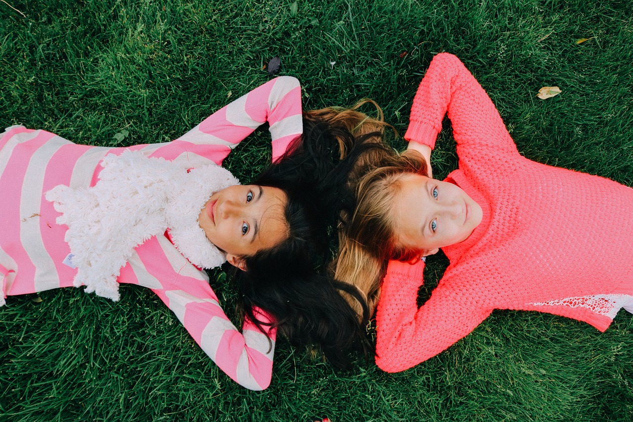Dwoje dzieci leżące na trawie